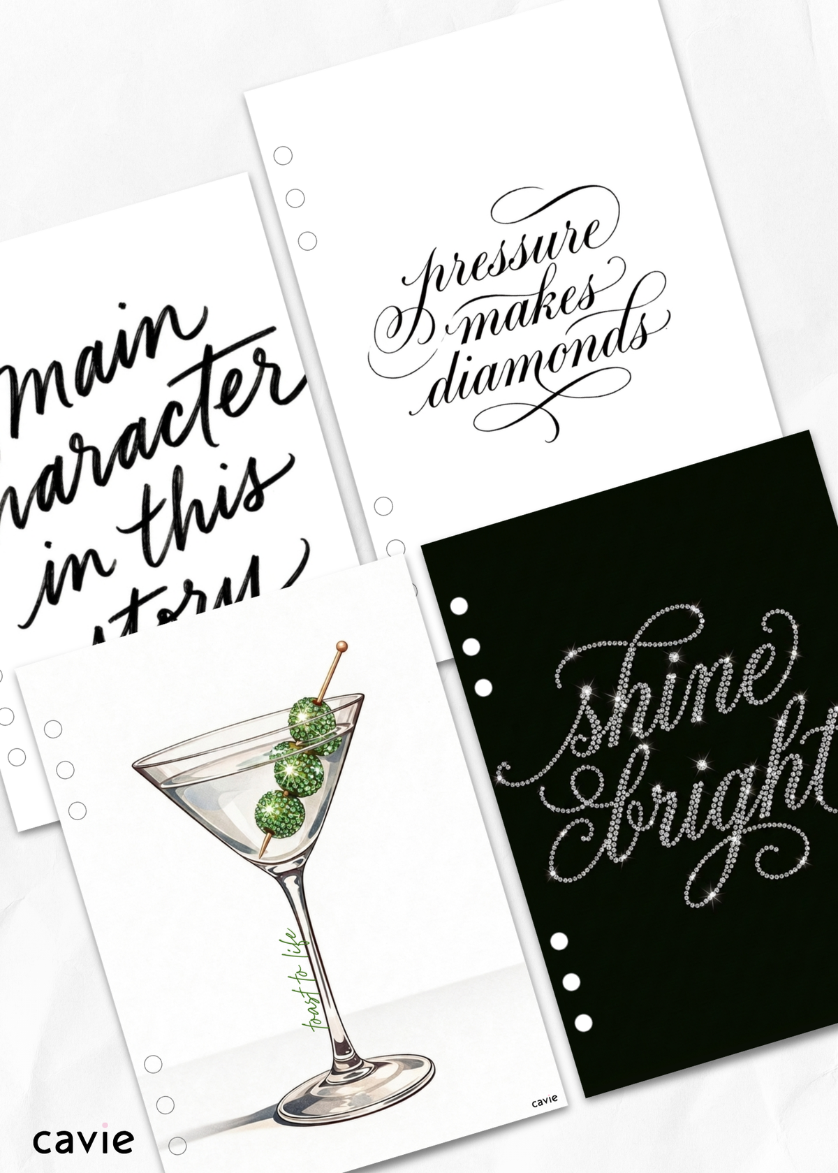 A set of decorative printed sheets or cards with black and white script text and one illustration of a martini glass with green olives, arranged on a light background. Visible text includes phrases such as 'main character in this story,' 'pressure makes diamonds,' and 'shine bright.