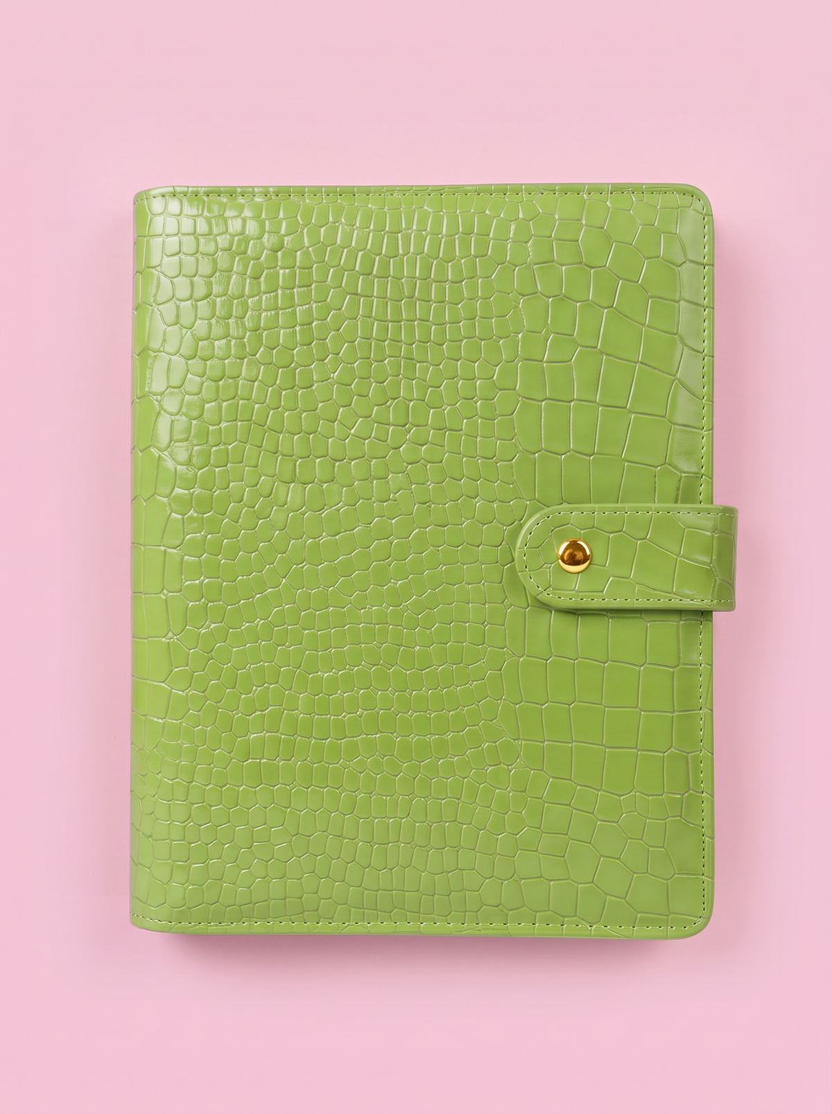 Matcha green crocodile-print A5 six-ring planner by Cavie, flat-lay on a pink background