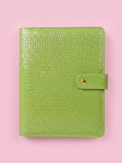Matcha green crocodile-print A5 six-ring planner by Cavie, flat-lay on a pink background