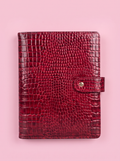 Scarlet red crocodile-print A5 six-ring planner by Cavie, flat-lay on a pink background